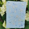 Seedgirls Karte "Antiquariat" in blau mit eingeschöpften Papierschnipseln einer alten Buchseite